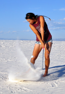 Camille Orito from the NMSU Women's Golf Team hitting a golf shot at White Sands National Monument in New Mexico.