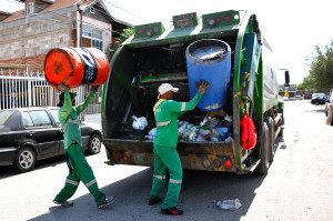 Daniel Tonche and Jose Sanchez dispose garbage into truck in the streets of Ciudad Juárez.