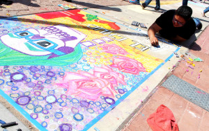Marisol Avila drawing El Chuc at the chalk the block event.