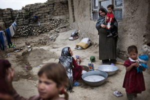Aneesa (right), a widow, talks to her neighbor while their children play on the hill where they live in Kabul, Afghanistan, June 30, 2011.
