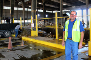Robert Gorman stands among all the commotion of the transfer station floor 
