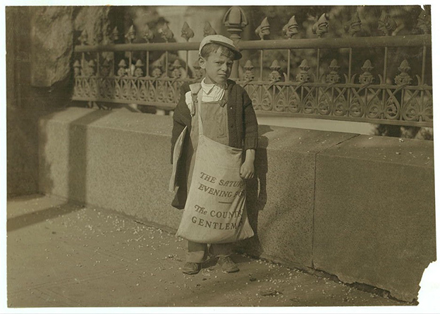 This photo was taken by Lewis Hine in 1915 while he was working as an investigative photographer for the National Child Labor Committee, which advocated for children’s rights to education, dignity, and well-being. This particular image smacks us with the reality that the profession of journalism has an ugly spot in its history. Here, 5-8 year-old, Freddie Kafer, is selling Saturday Evening Post newspapers at the entrance of the California State Capitol. Hine described his interaction with the boy, “He did not know his age, nor much of anything else. The bag weighed 24 pounds, and he weighed only 55 pounds. He carried this bag for several blocks to the car” (Library of Congress).
The efforts of the NCLC photographers and other members ignited a movement toward a ban on child labor. Now, several federal laws prohibit children under 14 from working, regulate working hours and times dependent upon school hours, and regulate the type of work minors can do (Department of Labor). 

