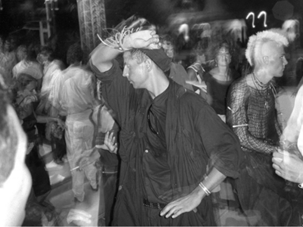 Derek Ridgers is a British who documented the 1980’s major club culture. He first focused on the bands that were performing at local London punk gigs, but then decided the crowd behind the front row was much more exciting (Hutchcraft, 2015). 
The above image was taken while on a family trip to Ibiza, the still-sought-after destination for clubgoers and ravers. Then, Ridgers would have been one of the few with a camera; leaving the partiers free of today’s phone distraction (notice the free hands and lack of arms in the air leading to posed selfies). 
When Ridgers first brought his images to the editors of The Face magazine the idea was rejected. However, a year later in the Sept. 1985 issue, the magazine ran his story and photos, and “Once people in the U.K. started to realize that Ibiza was cool – and had it confirmed by The Face magazine – everything changed” (Ridgers, 2018).
